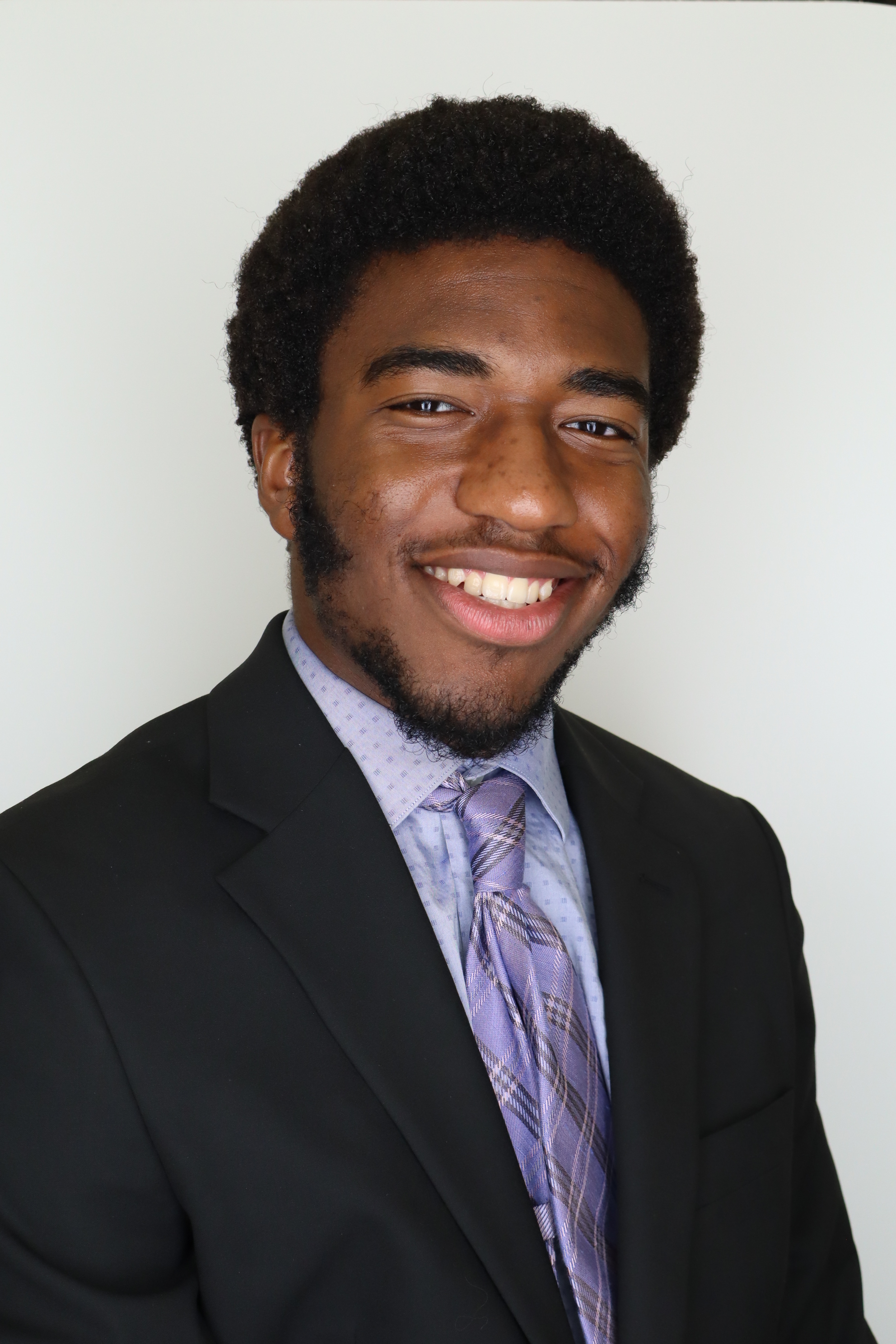 Chinedu holding a fishing rod by a lake, giving a thumbs up.